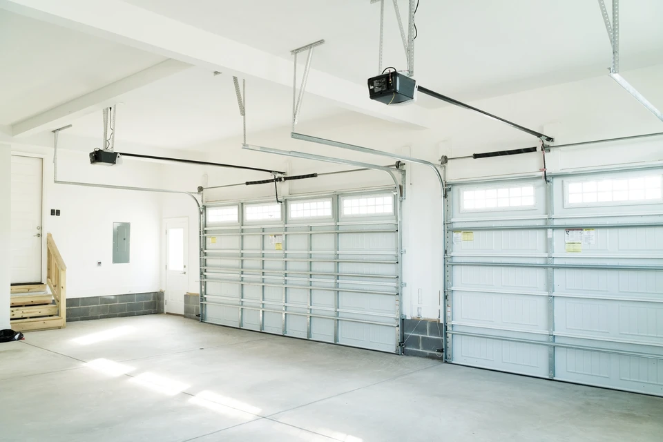 Garage résidentiel moderne avec deux portes sectionnelles métalliques blanches fermées