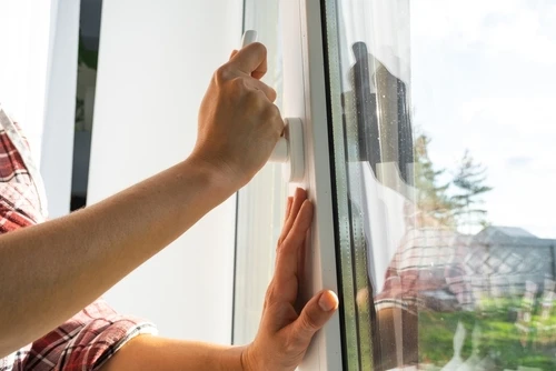 Travailleur installant une fenêtre en plastique à l'intérieur